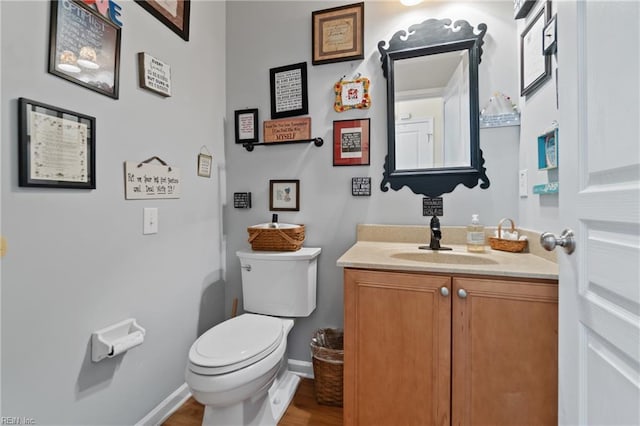 bathroom with vanity, toilet, and wood-type flooring