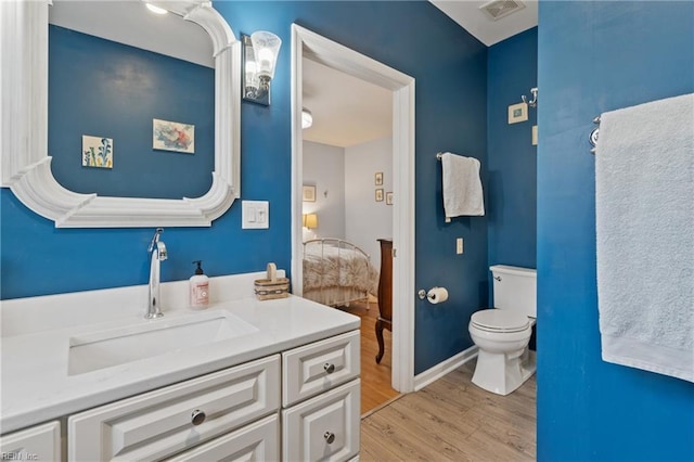 bathroom featuring vanity, toilet, and hardwood / wood-style floors