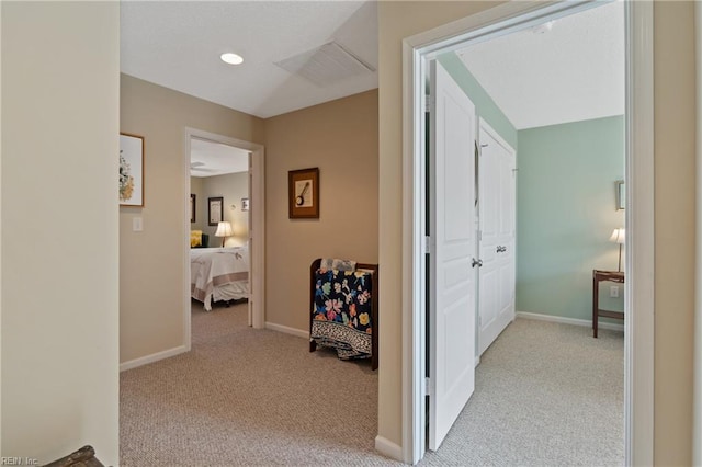 corridor featuring light colored carpet