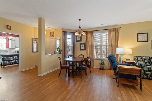 dining room featuring hardwood / wood-style flooring and an inviting chandelier