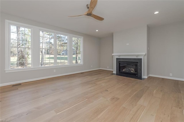 unfurnished living room with ceiling fan and light hardwood / wood-style flooring