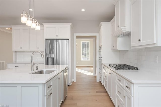 kitchen with white cabinetry, hanging light fixtures, and a center island with sink