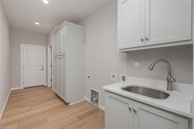 laundry room with sink, cabinets, light wood-type flooring, washer hookup, and hookup for an electric dryer