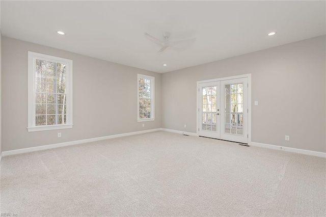 unfurnished room featuring light carpet, ceiling fan, and french doors