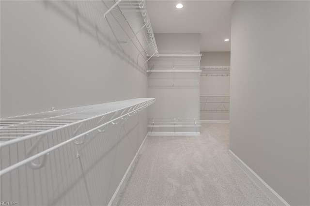 walk in closet featuring light colored carpet