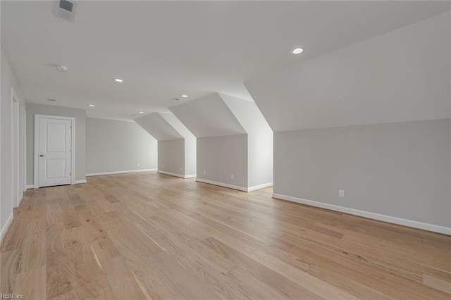 bonus room with vaulted ceiling and light hardwood / wood-style flooring