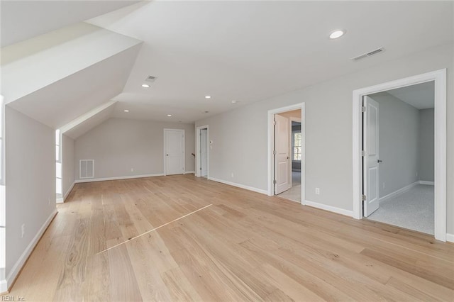 additional living space with lofted ceiling and light wood-type flooring