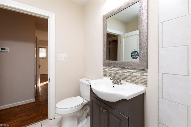 bathroom with vanity, backsplash, and toilet