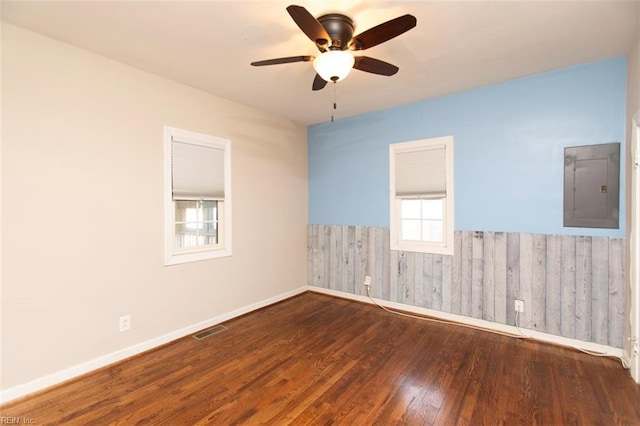 unfurnished room with dark wood-type flooring, electric panel, and ceiling fan