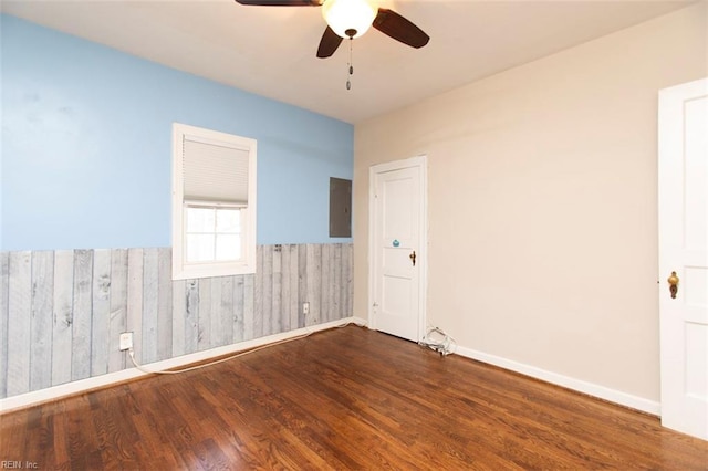 empty room featuring hardwood / wood-style flooring, electric panel, and ceiling fan