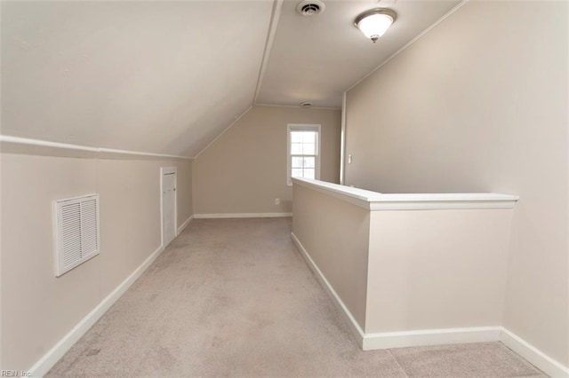 interior space with light colored carpet and vaulted ceiling