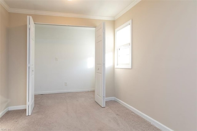 unfurnished bedroom with crown molding, light carpet, and a closet