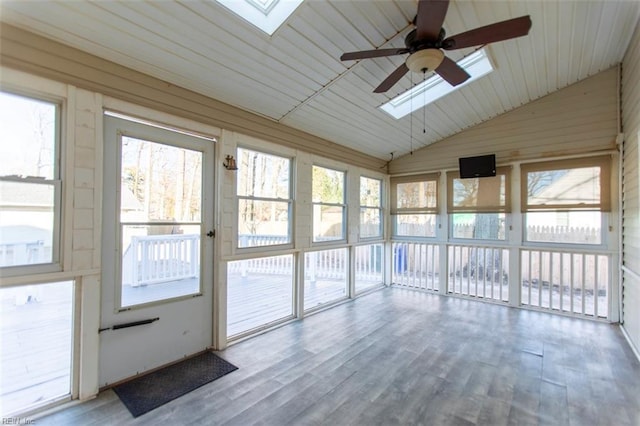 unfurnished sunroom with ceiling fan and vaulted ceiling with skylight