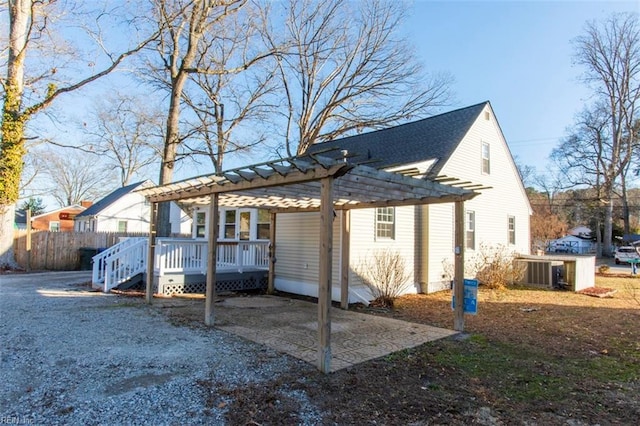 rear view of house with a pergola, central AC, and a deck