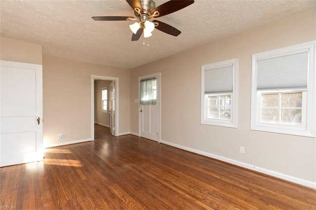 unfurnished room with ceiling fan, dark hardwood / wood-style floors, and a textured ceiling