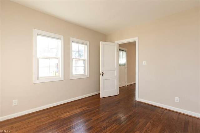 unfurnished room with dark hardwood / wood-style flooring