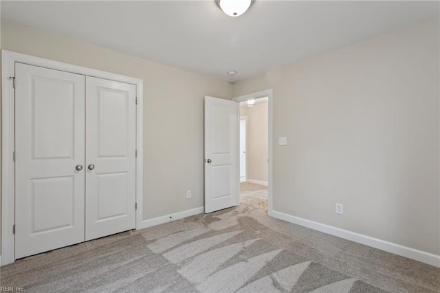 unfurnished bedroom featuring light carpet and a closet