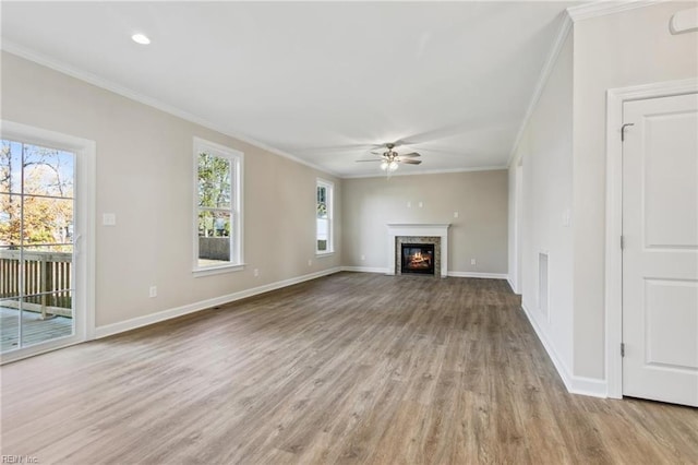 unfurnished living room featuring ceiling fan, ornamental molding, and light hardwood / wood-style flooring