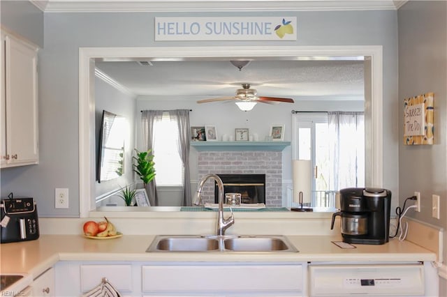 kitchen with white dishwasher, sink, and white cabinets