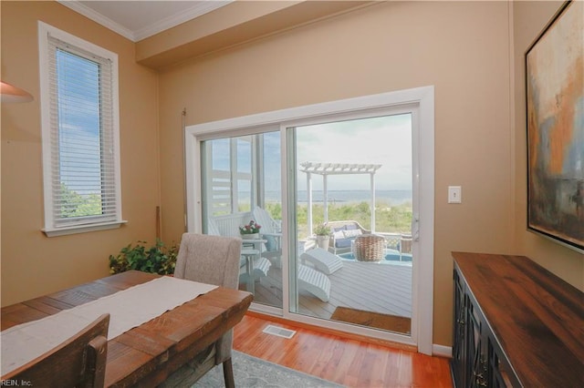 doorway to outside featuring hardwood / wood-style floors and crown molding