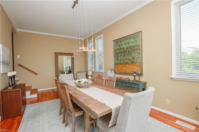 dining room with crown molding and wood-type flooring