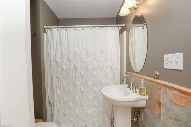 bathroom with sink and tile walls