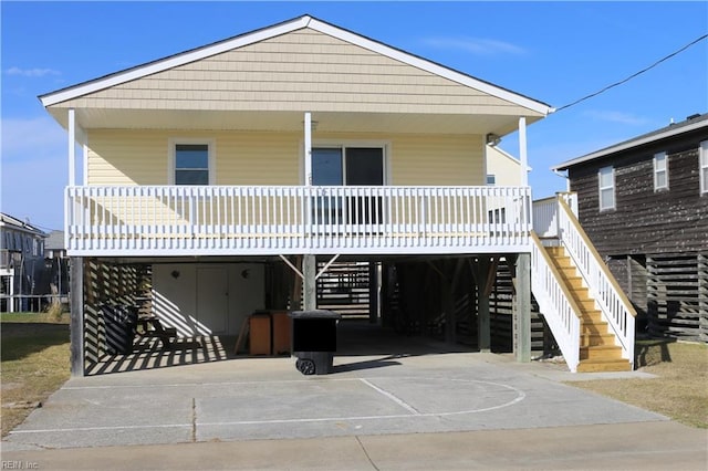 raised beach house featuring a carport and covered porch