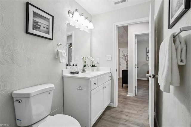 bathroom with vanity, hardwood / wood-style floors, and toilet