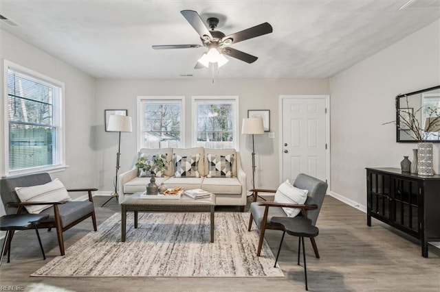 living room with ceiling fan, wood-type flooring, and a healthy amount of sunlight