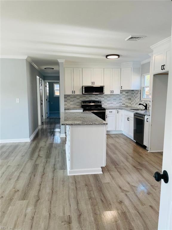 kitchen with white cabinetry, light stone counters, range with electric cooktop, and dishwasher