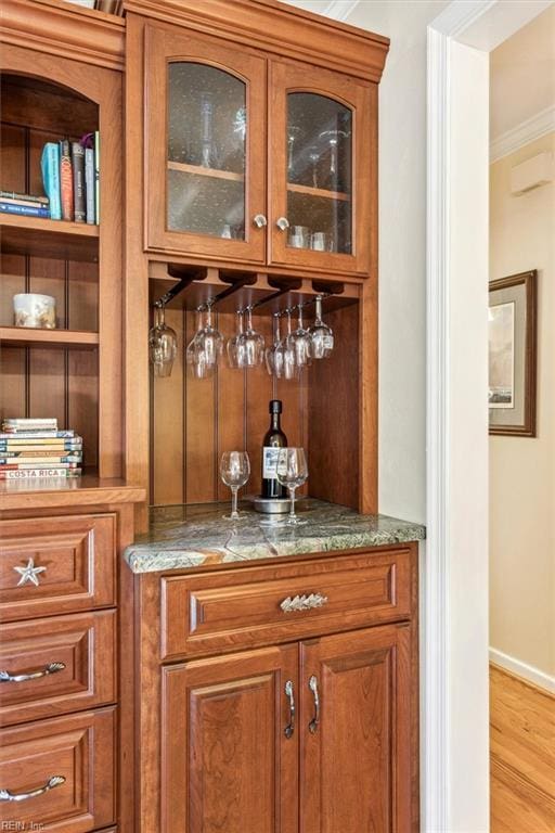 bar featuring light hardwood / wood-style flooring and ornamental molding