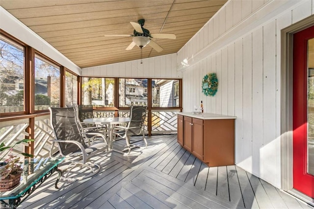 sunroom / solarium featuring vaulted ceiling, wooden ceiling, and ceiling fan