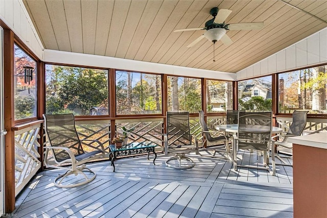 unfurnished sunroom with ceiling fan, lofted ceiling, a wealth of natural light, and wood ceiling