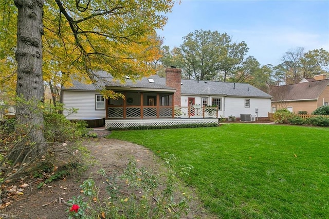 back of property with central AC unit and a lawn