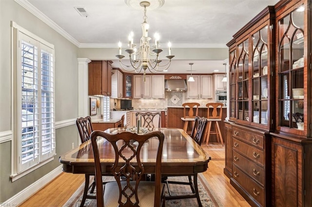 dining area with a healthy amount of sunlight, a chandelier, and light hardwood / wood-style flooring