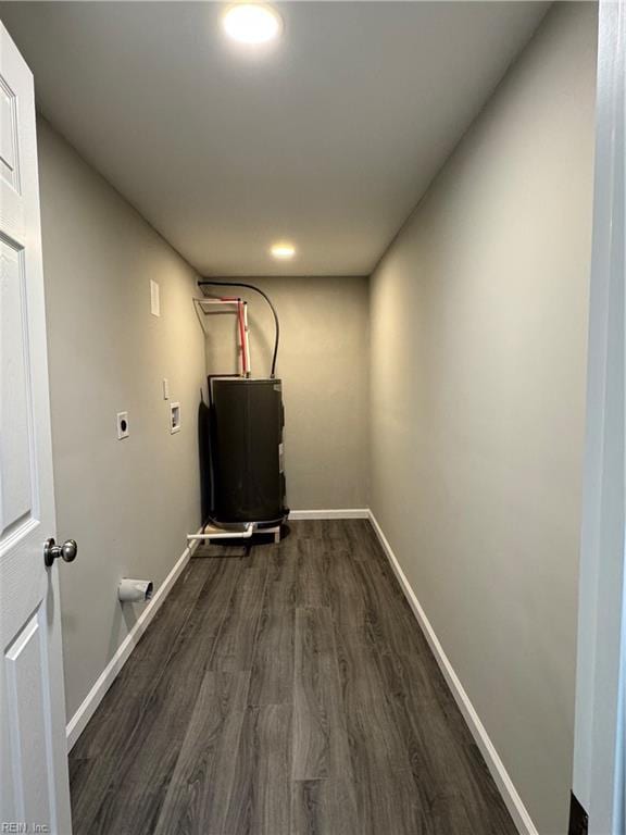 washroom with electric water heater, dark wood-type flooring, and hookup for an electric dryer