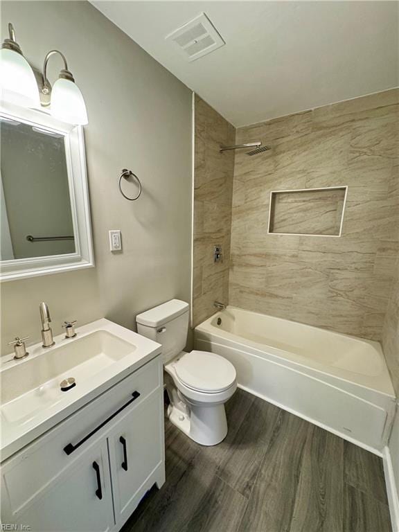 full bathroom with vanity, hardwood / wood-style flooring, toilet, and tiled shower / bath