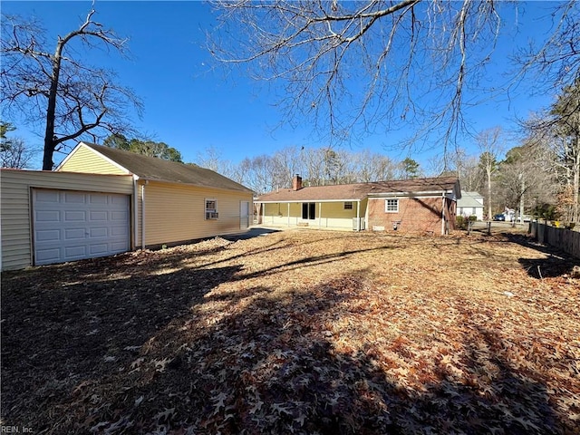 rear view of property with an outbuilding and a garage