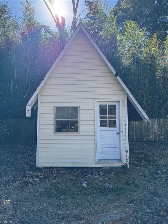 view of side of home featuring a storage shed