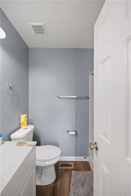 bathroom featuring vanity, toilet, and wood-type flooring