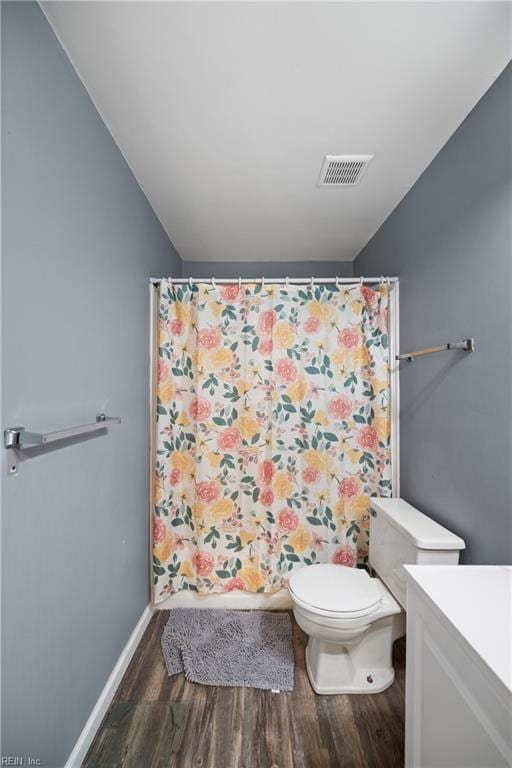 bathroom with vanity, hardwood / wood-style flooring, lofted ceiling, and toilet