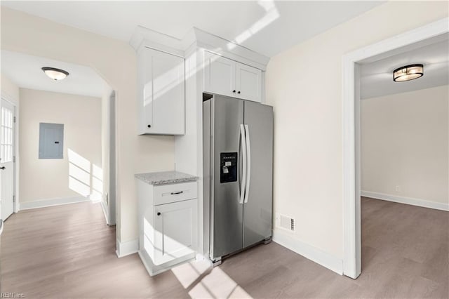 kitchen featuring light hardwood / wood-style floors, electric panel, stainless steel fridge with ice dispenser, and white cabinets