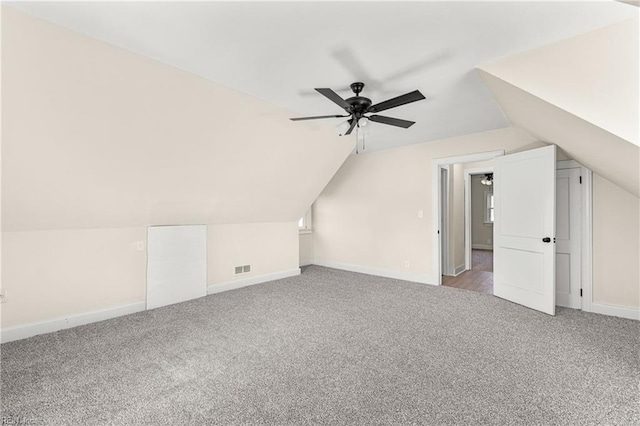 bonus room with vaulted ceiling, light colored carpet, and ceiling fan