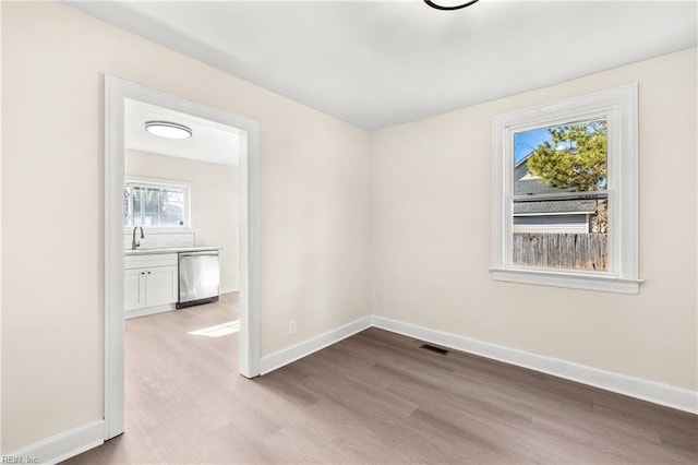 spare room with sink and light hardwood / wood-style flooring