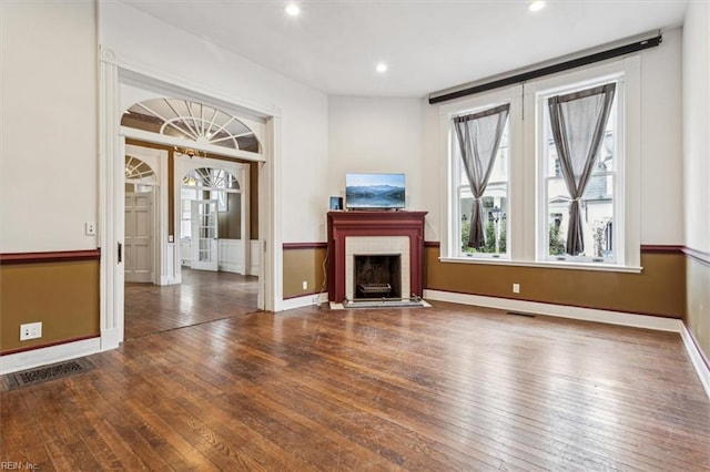 unfurnished living room with dark hardwood / wood-style flooring and french doors