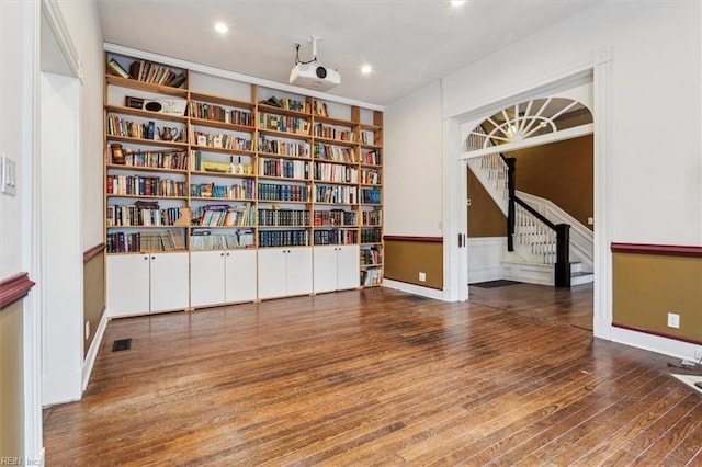 empty room with built in features and dark hardwood / wood-style flooring