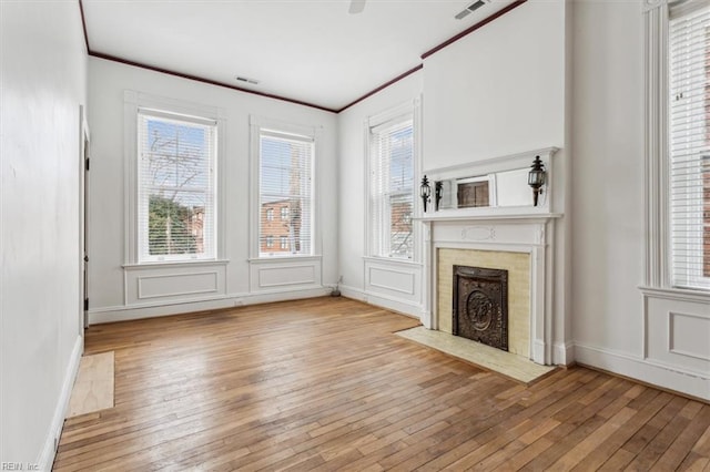 unfurnished living room with light hardwood / wood-style flooring and ornamental molding