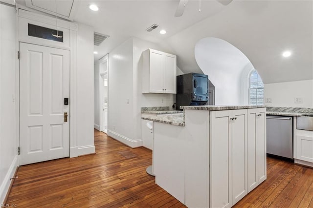 kitchen featuring white cabinetry, a center island, dishwasher, and light stone counters