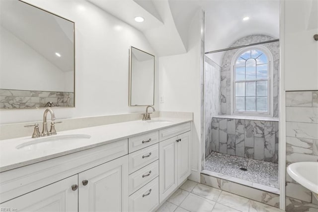 bathroom with tiled shower and vanity