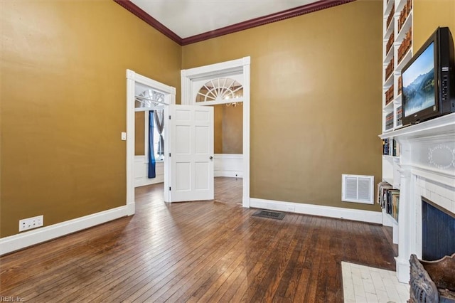 unfurnished living room with ornamental molding and hardwood / wood-style floors